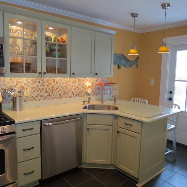 kitchen featuring dark tile patterned floors, crown molding, appliances with stainless steel finishes, and a sink