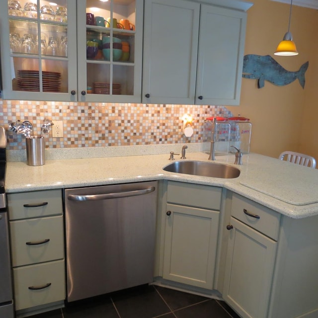 kitchen with decorative backsplash, dishwasher, dark tile patterned flooring, a peninsula, and a sink