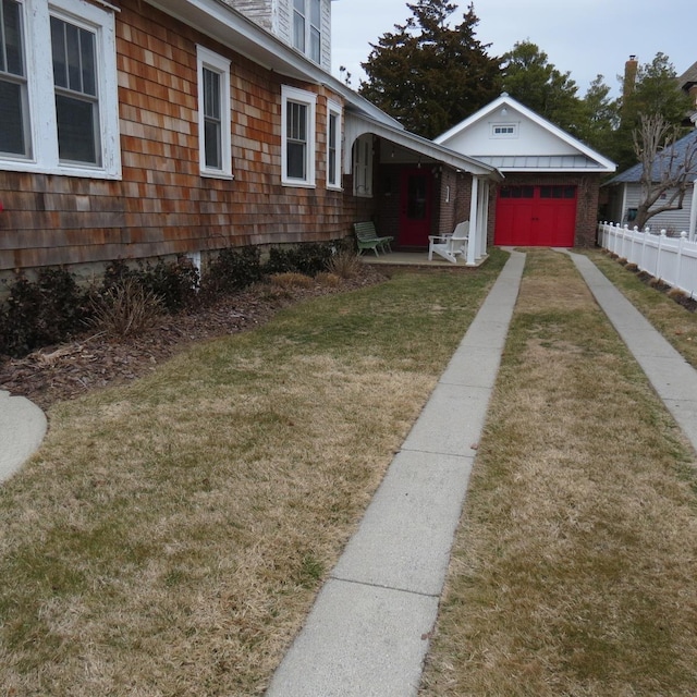 view of yard featuring fence, driveway, and an attached garage