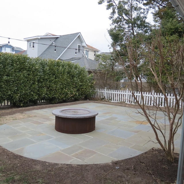 view of patio / terrace with a fire pit and fence