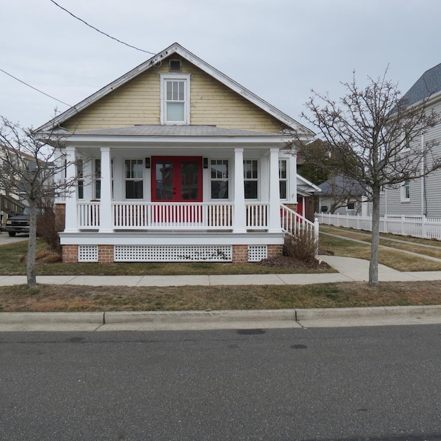 view of front of property with a porch and fence