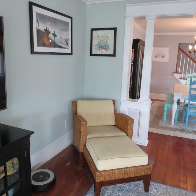 living area with wood finished floors, baseboards, stairway, decorative columns, and crown molding