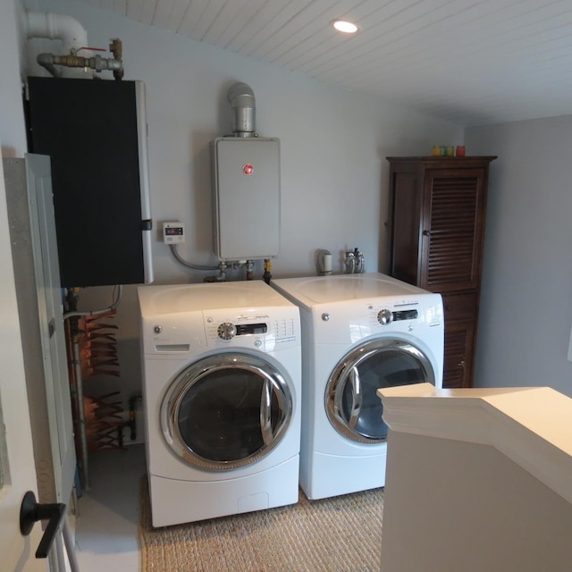 washroom featuring water heater, laundry area, recessed lighting, and washer and dryer