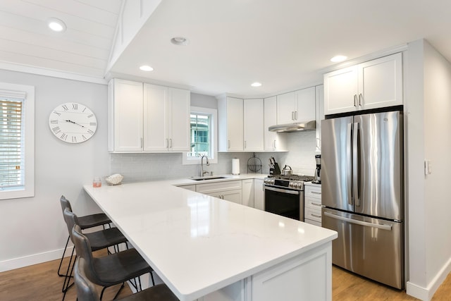 108 27th St, Avalon, NJ 08202 - kitchen featuring appliances with stainless steel finishes, a sink, a breakfast bar, a peninsula, and decorative backsplash