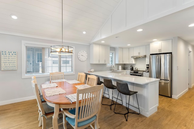 108 27th St, Avalon, NJ 08202 - kitchen featuring stainless steel appliances, lofted ceiling, a peninsula, under cabinet range hood, and white cabinets