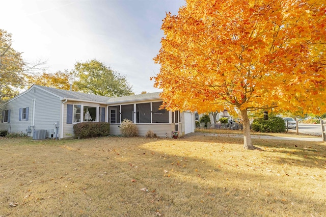 view of front of property with a sunroom, cooling unit, and a front yard