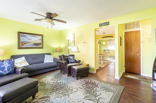 living room featuring ceiling fan and dark hardwood / wood-style floors