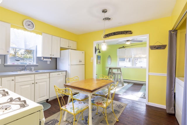 kitchen with sink, dark wood-type flooring, hanging light fixtures, white appliances, and white cabinets