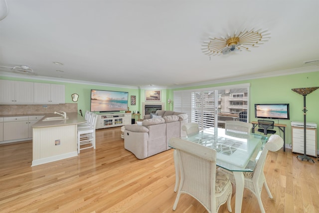902 Ocean Dr Unit 306, Lower Township, NJ 08204 - dining room with visible vents, ornamental molding, a glass covered fireplace, and light wood-style floors