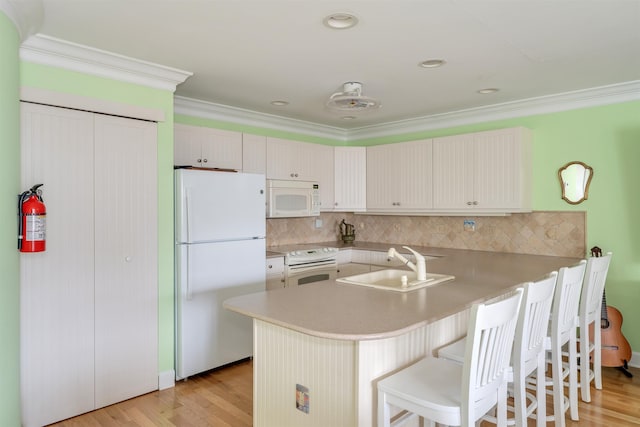 902 Ocean Dr Unit 306, Lower Township, NJ 08204 - kitchen with white appliances, a peninsula, a breakfast bar, a sink, and light wood finished floors