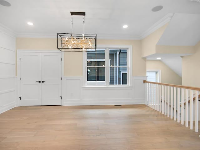 unfurnished dining area with crown molding and light hardwood / wood-style floors