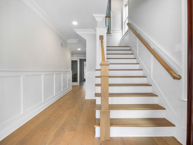 stairs featuring hardwood / wood-style floors and crown molding