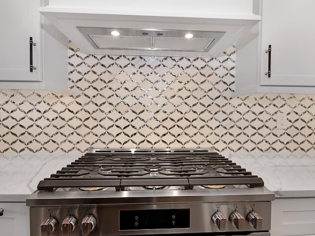 kitchen featuring white cabinetry, stainless steel range, and light stone counters