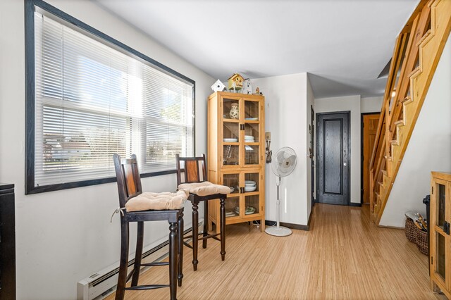 94 Delaware Ave, Fortescue, NJ 08321 - dining room with light wood-style floors, baseboards, a baseboard heating unit, and stairs