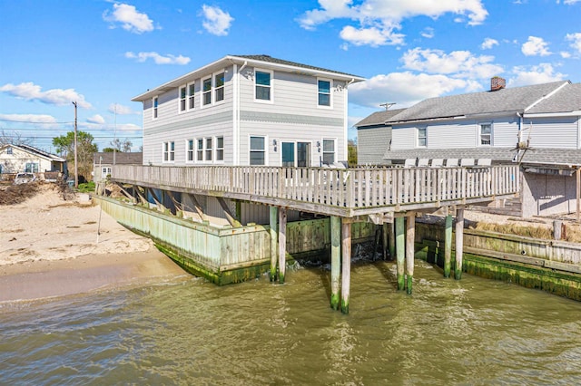 rear view of house featuring a deck with water view