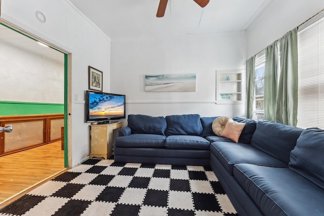 living room featuring ceiling fan, light wood-type flooring, and ornamental molding