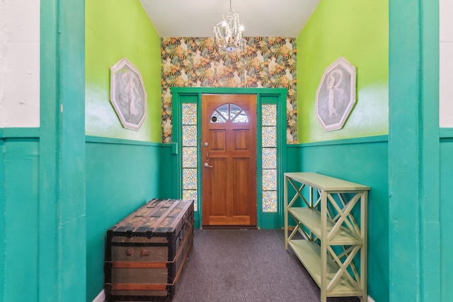 carpeted entryway with an inviting chandelier