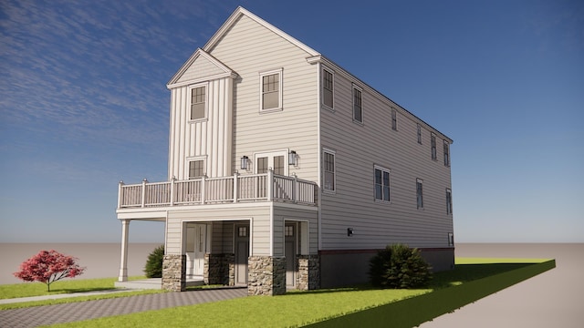 rear view of house featuring a balcony and a yard