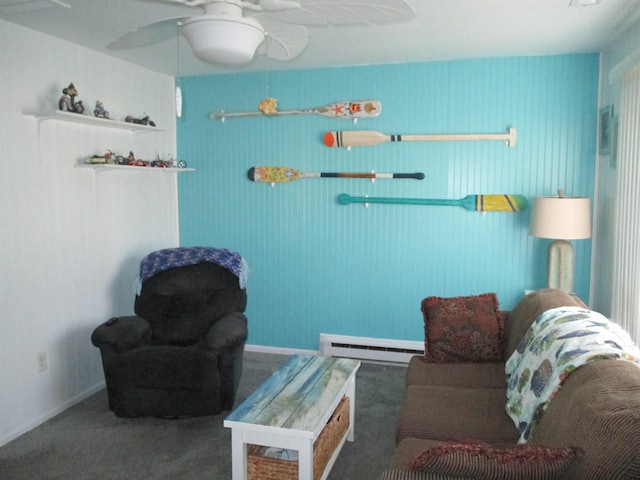 living area with baseboard heating, ceiling fan, and dark colored carpet