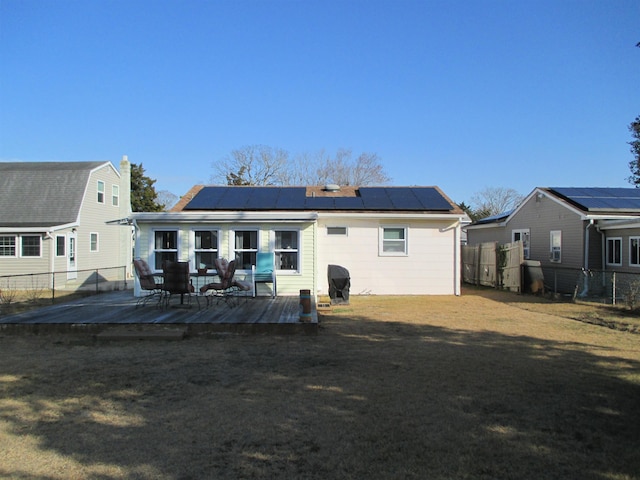 rear view of house featuring solar panels, a patio area, and a deck