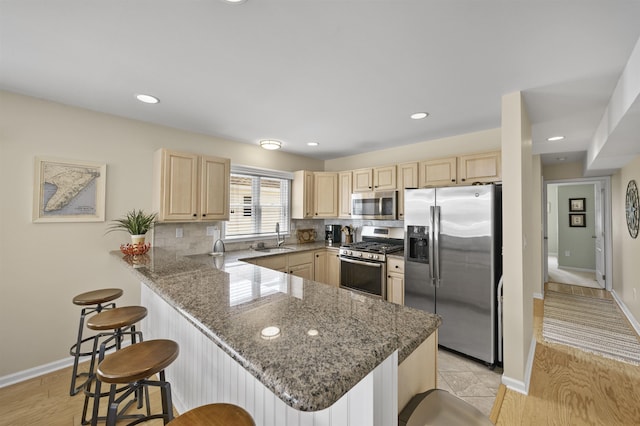 2026 6th Ave Unit S, Avalon, NJ 08202 - kitchen featuring stainless steel appliances, light brown cabinetry, a sink, a peninsula, and a breakfast bar area