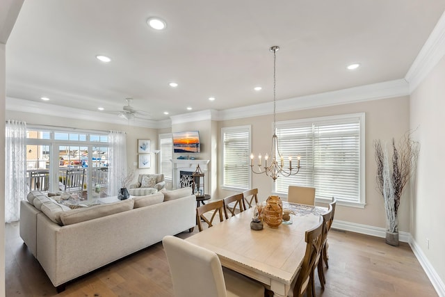 dining area featuring baseboards, light wood-style flooring, recessed lighting, a fireplace, and ornamental molding