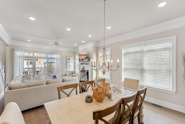 dining space with visible vents, ornamental molding, and a fireplace