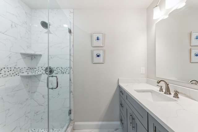 bathroom featuring marble finish floor, a stall shower, vanity, and baseboards