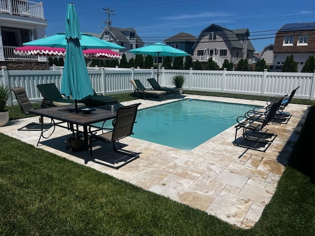 view of pool with a fenced in pool, fence, a lawn, and a patio area