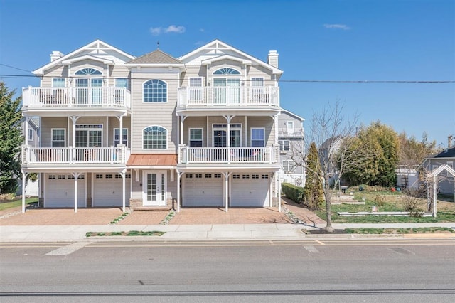 145 W Andrews Ave Unit 100, Wildwood, NJ 08260 - view of front facade featuring a garage, a chimney, a balcony, and decorative driveway