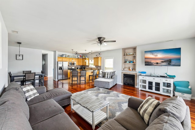 145 W Andrews Ave Unit 100, Wildwood, NJ 08260 - living area featuring dark wood finished floors, a ceiling fan, and a tiled fireplace