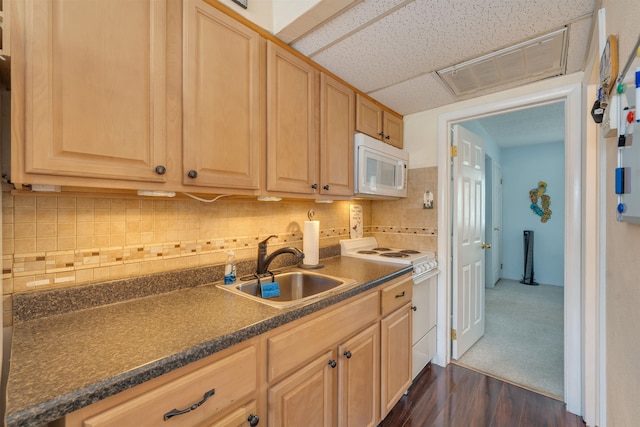 kitchen featuring light brown cabinetry, a drop ceiling, white appliances, dark wood-type flooring, and sink