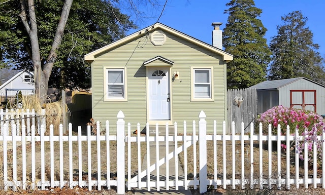 bungalow-style house featuring a storage shed