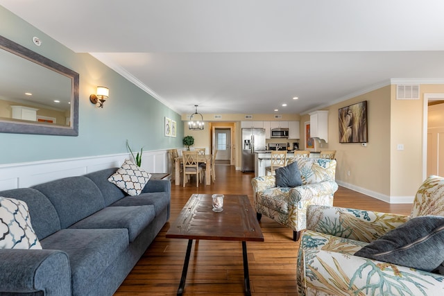 living room with crown molding, dark hardwood / wood-style floors, and a notable chandelier