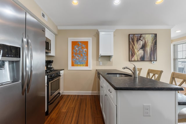 kitchen featuring sink, stainless steel appliances, a breakfast bar, and white cabinets