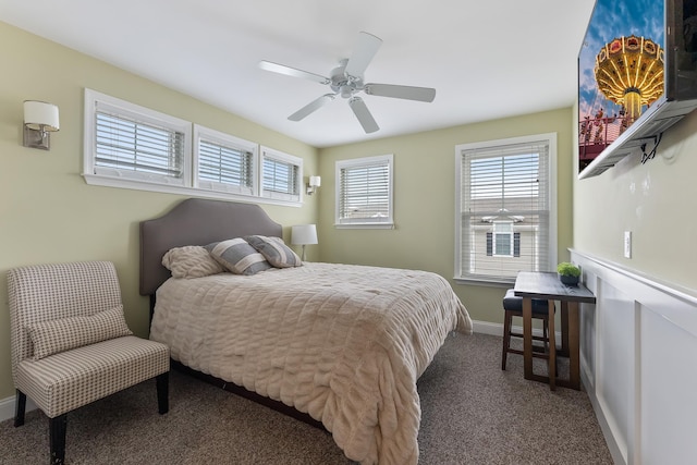 bedroom with multiple windows, ceiling fan, and dark carpet