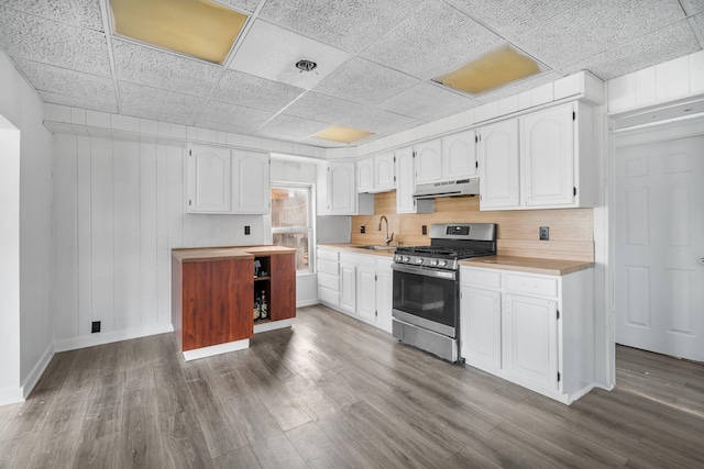 kitchen featuring a drop ceiling, sink, stainless steel gas stove, dark hardwood / wood-style floors, and white cabinetry