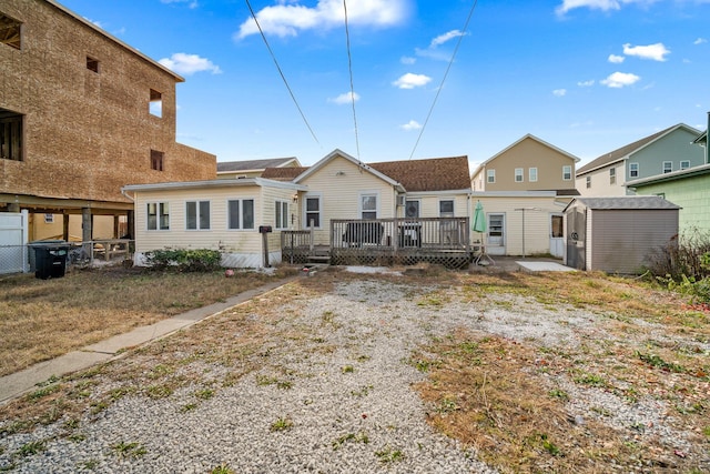 back of property with a shed and a deck