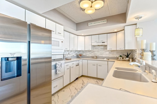 kitchen featuring marble finish floor, light countertops, decorative backsplash, a sink, and stainless steel fridge with ice dispenser