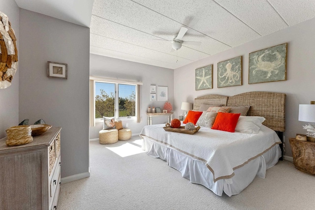 bedroom with light carpet, a ceiling fan, and baseboards