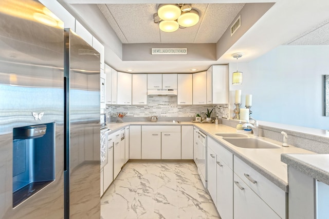 kitchen with a sink, visible vents, marble finish floor, stainless steel refrigerator with ice dispenser, and backsplash