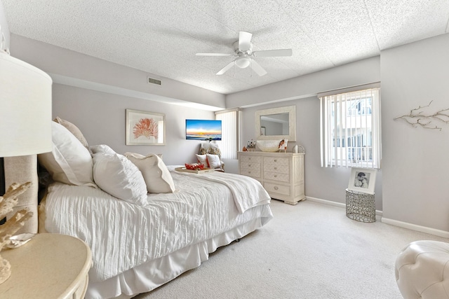 bedroom with baseboards, visible vents, ceiling fan, and light colored carpet