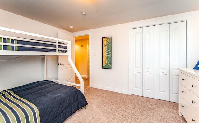 bedroom featuring light colored carpet and a closet