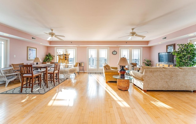 living room with light hardwood / wood-style floors, a wealth of natural light, and ceiling fan