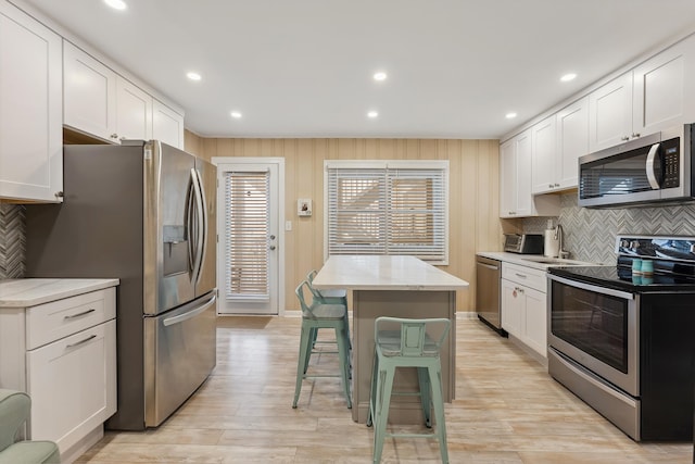 kitchen with a center island, stainless steel appliances, and white cabinetry