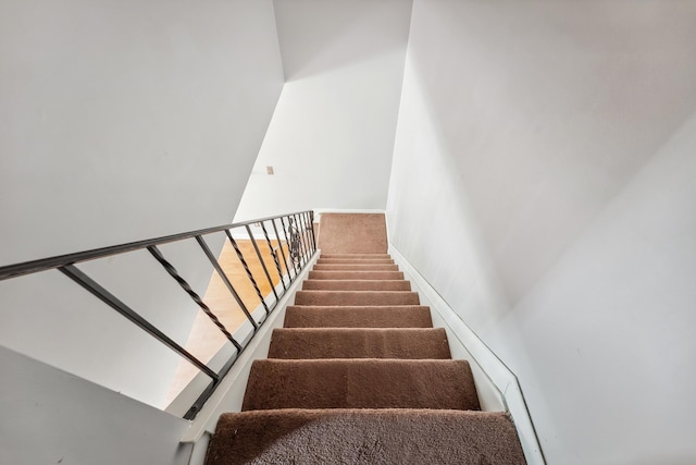 stairway with baseboards and carpet