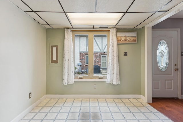 foyer with a paneled ceiling and baseboards