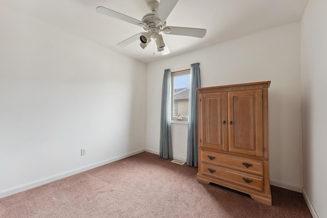 unfurnished bedroom with baseboards, light carpet, visible vents, and a ceiling fan