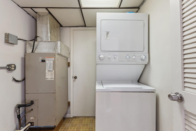 laundry room featuring laundry area, heating unit, and stacked washing maching and dryer