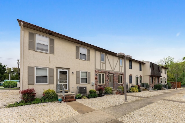 view of property featuring stucco siding and central AC unit